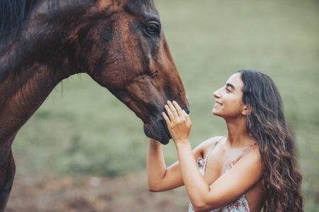 A woman petting a horse